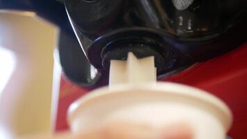 close up view to ice cream maker machine in soft serve style while make a cone of fresh milk ice cream video