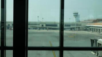 verschwommen aus von Fokus Aussicht durch Fenster von das Flughafen Terminal im tagsüber zu das Flugzeug Parkplatz Bereich video