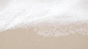 close up to Sea waves rolling over the fine sand beach, waves break on white sand beach with beautiful foam, tropical summer vacation holiday nature background video