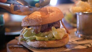utilizando cuchillo a cortar Fresco hecho en casa jugoso hamburguesa lleno con salsa tocino vegetal y gigante carne empanada video