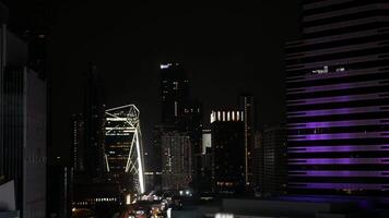 aerial night time landscape skyline of Bangkok city in night time with light on many highrise skyscraper buildings with some traffic. video