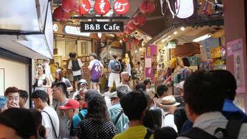 panorama Visão do pessoas enquanto caminhando às caminhando compras rua dentro Jioufen velho aldeia, famosa turista Comida rua destino com lotado do pessoas video