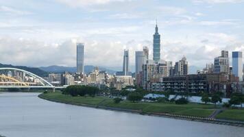 horizontal landscape view of the Taipei capital city of the Taiwan with highrise skyscraper building under sunset twillight sky time with windy cloudy weather. video