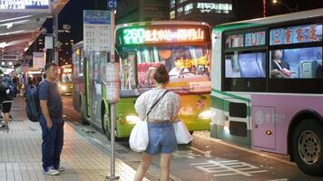 offentlig buss sluta i stad Centrum av taipei med många passagerare väntar, skaffa sig på och skaffa sig av från de buss i natt tid video