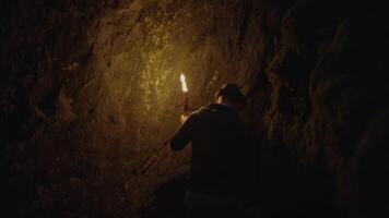 hombre participación un ardiente antorcha explorador bosque cueva paisaje en oscuro noche video