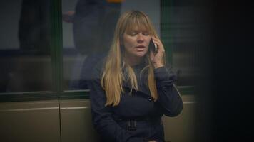 blond femme parlant en colère sur mobile téléphone à gare argumenter video