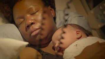 svart kvinna med lockigt hår vilar i leverans rum med spädbarn barn video