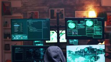 espalda ver de masculino hacker vistiendo un capucha infectando gobierno servidor con un peligroso virus. video