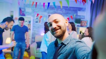 Pov of attractive bald man waving at the camera while partying with his friends video