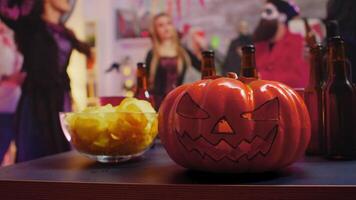 Group of people with costumes celebrating halloween and dancing. Chips and beer for the party. video