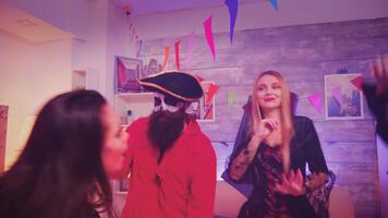 Zoom out shot of friends celebrating halloween in costumes, dancing and having a lot of fun video