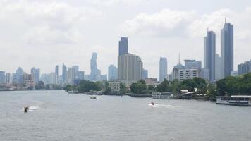 panorama landscape view of chaopraya river with river water boat transportation and background of bangkok city skyline with many highrise skyscraper video