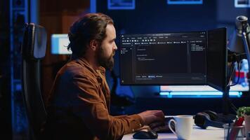 programmerare håller på med webb utveckling under avlägsen jobb flytta i neon belyst Hem kontor, efterbehandling kodning projekt. den specialist Sammanträde på dator skrivbord, arbetssätt på skrivbordet pc, kamera en video