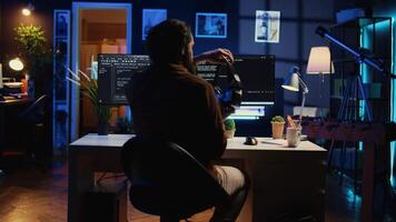 Teleworking programmer using futuristic VR glasses in home office to do javascript programming. IT expert wearing high tech virtual reality headset to visualize lines of code, camera B video