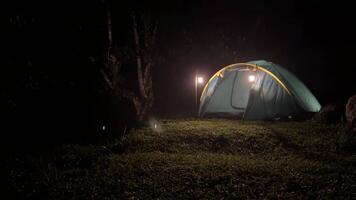 movimento sfondo avventura un' tenda è illuminato su a notte nel il foresta video