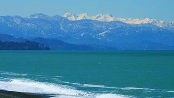 bellissimo visualizzazioni di il mare e il snow-capped montagne. neve capped montagna e cielo. ancora. video