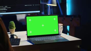 Green screen laptop in home office used for developing software applications. Mockup notebook used by teleworking IT specialist for programming, camera A close up panning shot video