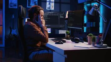 geërgerd software technicus wrijven tempels in frustratie na faalt naar verwijderen bugs verschijnen terwijl codering Aan computer. telewerker gevoel geërgerd door script fouten, sluitend ogen, camera b video
