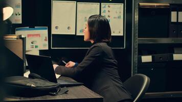 Private investigator comparing sources to confirm case details or cross check confidential information, compiling statistical data on crime trends. Asian federal agent in incident room. Camera A. video