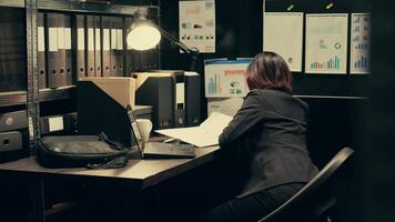 Detective uses forensic techniques to examine evidence stored in the archive, browsing through old classified documents to uncover clues. Private inspector studying classified information. Camera B. video