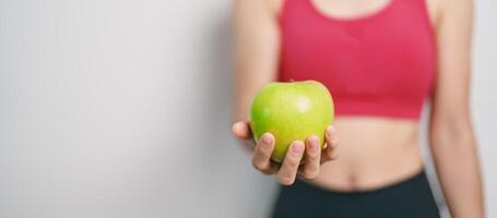 mujer mano sostener verde manzana, contento hembra aptitud escoger Fruta es sano alimento. dieta control, peso pérdida, obesidad, comiendo estilo de vida y nutrición conceptos foto