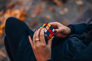 Italia, Milán enero 29, 2024. rubiks cubo estaba inventado en 1974 por húngaro escultor y profesor de arquitectura erno Rubik. manos de un joven dama molesto a resolver el rompecabezas. foto