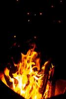 Logs are burning. Bonfire and sparks at night photo