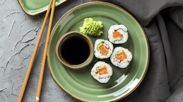 ai generado un verde plato adornado con futomaki Sushi, acompañado por un pequeño cuenco de shoyu. dos palillos descanso al lado de, atractivo un culinario experiencia. foto