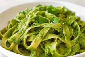 AI Generated Fettuccine ramp pesto pasta garnished with fresh herbs, close up photo