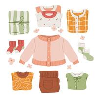 Assorted baby clothes set on a white background. Variety of child garments including a pair of socks, a sweater and shirts with different patterns and designs. Collection of cute kids apparel. vector