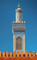 ai generado el detallado decoraciones en un alminar torre contraste bruscamente con un claro azul cielo foto