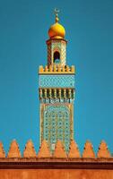 AI generated The complex artwork on a minaret tower is accentuated by the clear blue sky photo