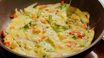 hand with spatula slicing omelet with fresh vegetables video