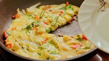 hand with spatula slicing omelet with fresh vegetables video