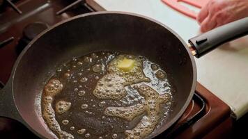 view of woman adding fresh vegetables from cutting board to frying pan with melted butter for frying video