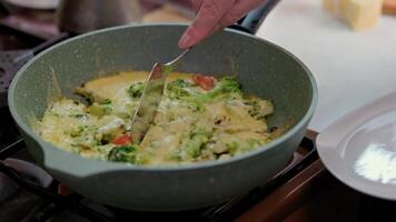 hand with spatula slicing omelet with fresh vegetables video