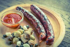 Grilled sausages with marinated vegetables photo