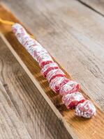 Cut spanish salami on the wooden board photo