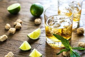 Glass of rum on the wooden background photo