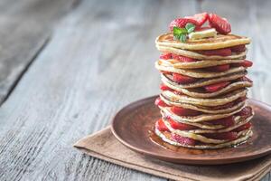 Stack of pancakes with fresh strawberries photo