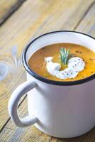 Mug of pumpkin cream soup photo