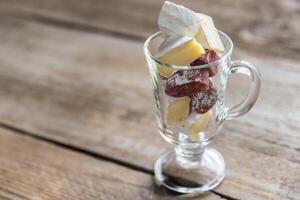 rebanadas de queso Camembert y salami en el vaso foto