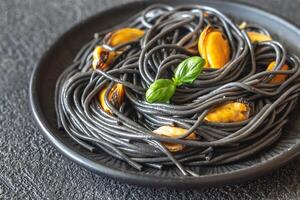 Black pasta with mussels and parmesan photo