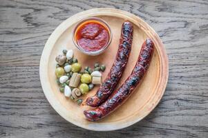 Grilled sausages with marinated vegetables photo