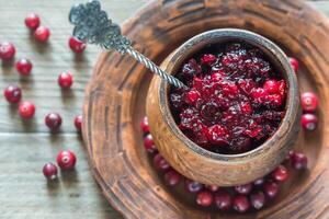 Bowl of cranberry sauce on the wooden board photo