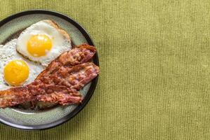Portion of fried eggs with bacon photo