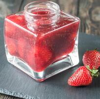 Glass jar of strawberry jam photo