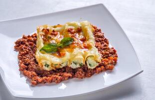 canelones relleno con ricotta con boloñesa salsa foto