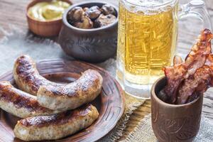 Grilled sausages with fried bacon rashers and mushrooms photo