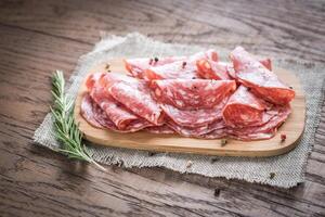 Slices of salami on the wooden board photo
